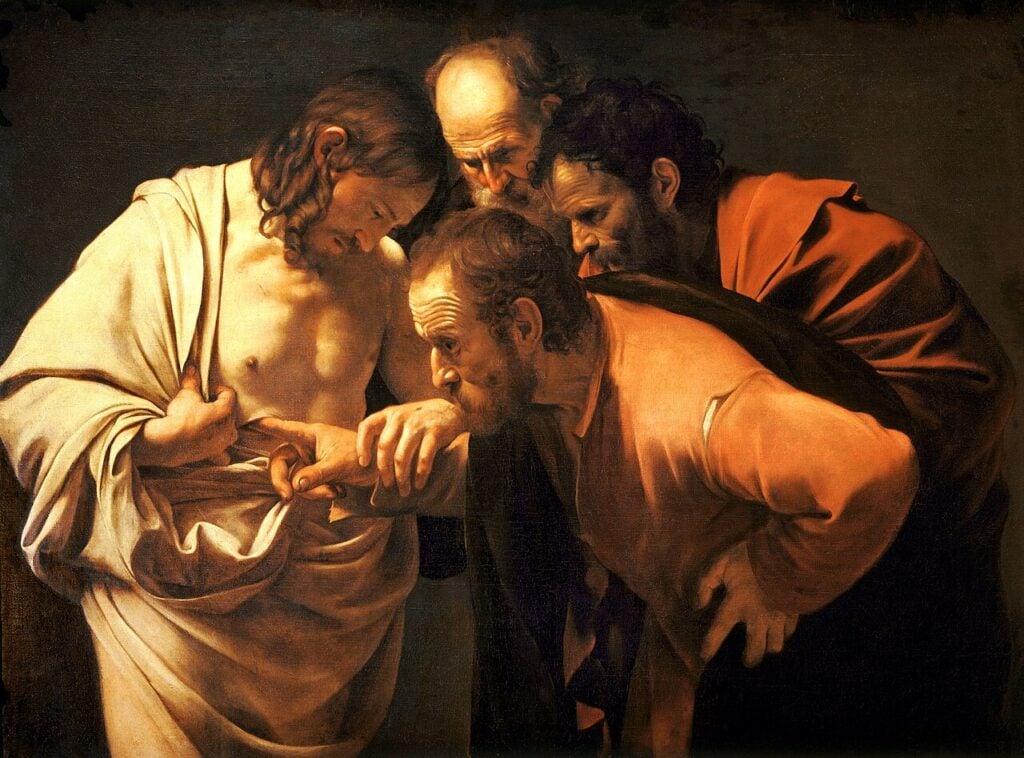 In Caravaggio's painting, Jesus bares his chest and, grabbing Thomas by the wrist, guides his finger into a gaping wound in his lower abdomen. Two other apostles stand behind Thomas, looking over his shoulder at the wound.